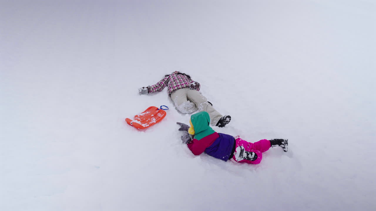 Asian Mother Playing in White Snow with Children in Colorful Winter Clothes