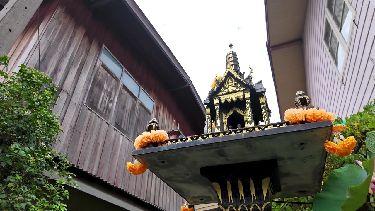 Tomada em ângulo baixo de um santuário de casa espiritual de madeira decorado com guirlandas de calêndula laranja