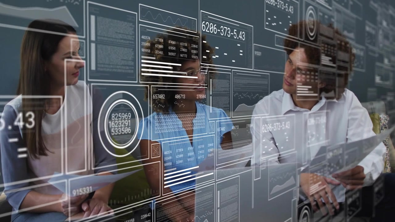 Colleagues right man leaning and pointing, analyst typing on laptop, HUD showing business charts