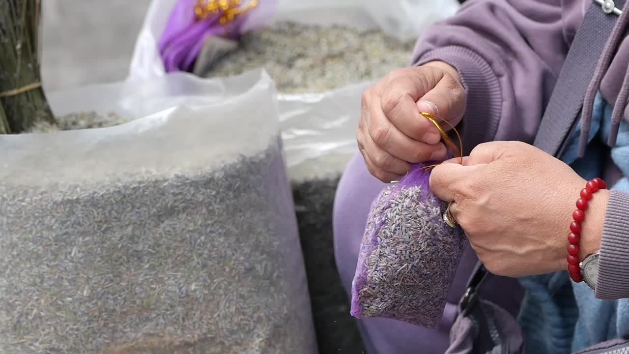 시장 에서 건조 한 라벤더 를 파는 여자