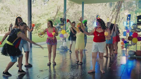 a group of people celebrating at a lively outdoor party with confetti and costumes