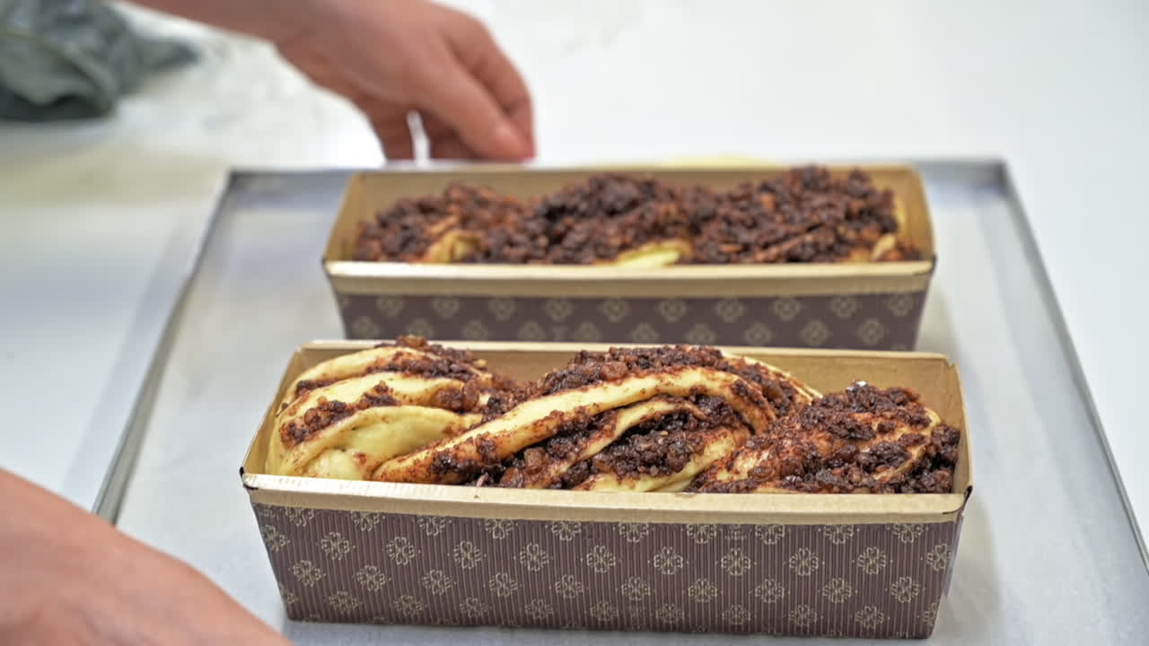 Cook taking a plate with raw dough with filling in a mold for making baked rolls. Slow motion
