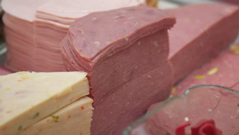 selection of sliced meats and cheeses at a deli counter