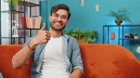 Happy-Indian-young-man-looking-approvingly-at-camera-show-thumbs-up-like-positive-sign-good-news