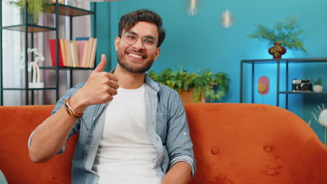 happy indian young man looking approvingly at camera show thumbs up like positive sign good news