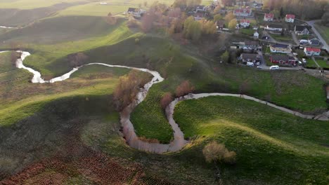 aerial shot of beautiful country town with hills and winding river landscape at sunrise, sweden