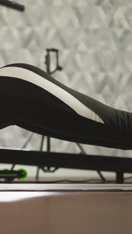 dama mantiene la postura de tabla baja demostrando fuerza. dama bien acondicionada realiza ejercicio de fitness en el suelo centrándose en aumentar la resistencia para un cuerpo tonificado