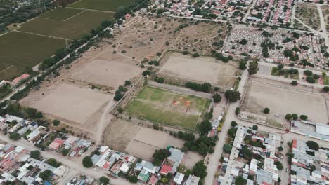 tomada aérea de un drone de un campo de fútbol vacío o de fútbol rodeado de casas residenciales de la ciudad de cafayate en argentina américa del sur