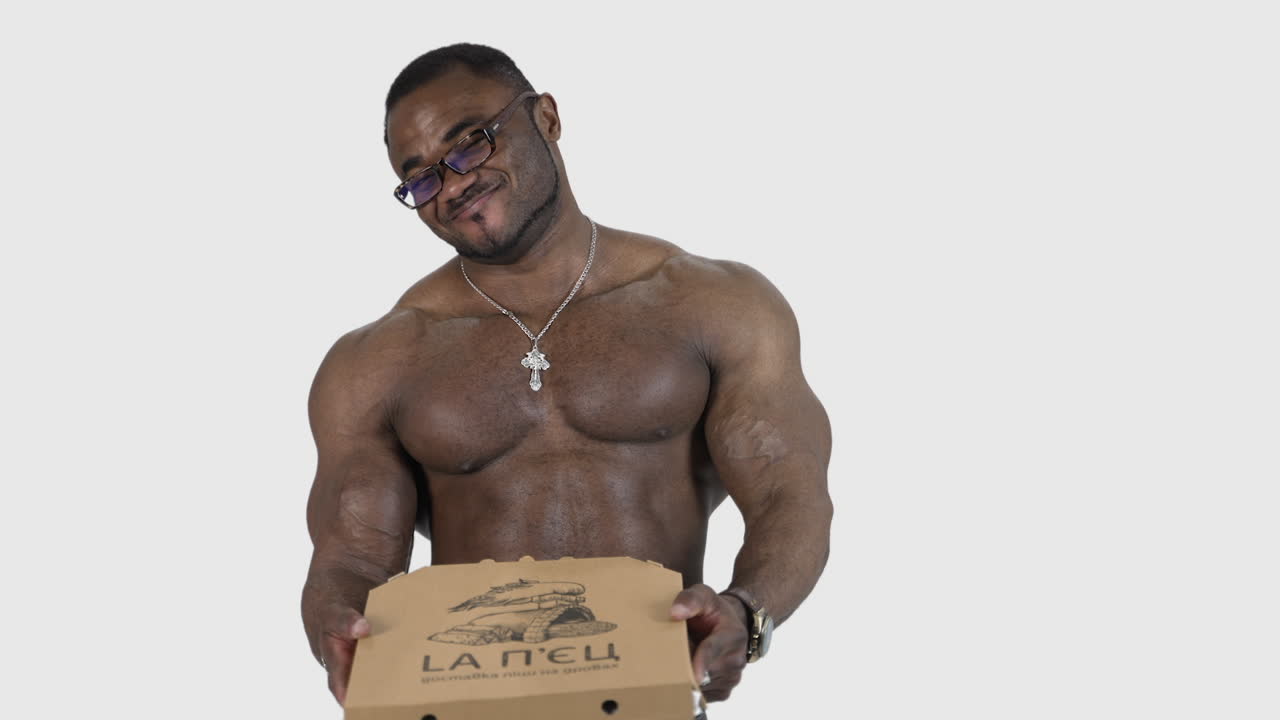 African man with pizza box. Fit man with pizza standing isolated over grey background in studio