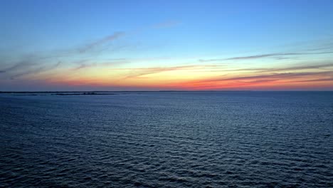 vibrant sunset with waves and colors, bahamas aerial view