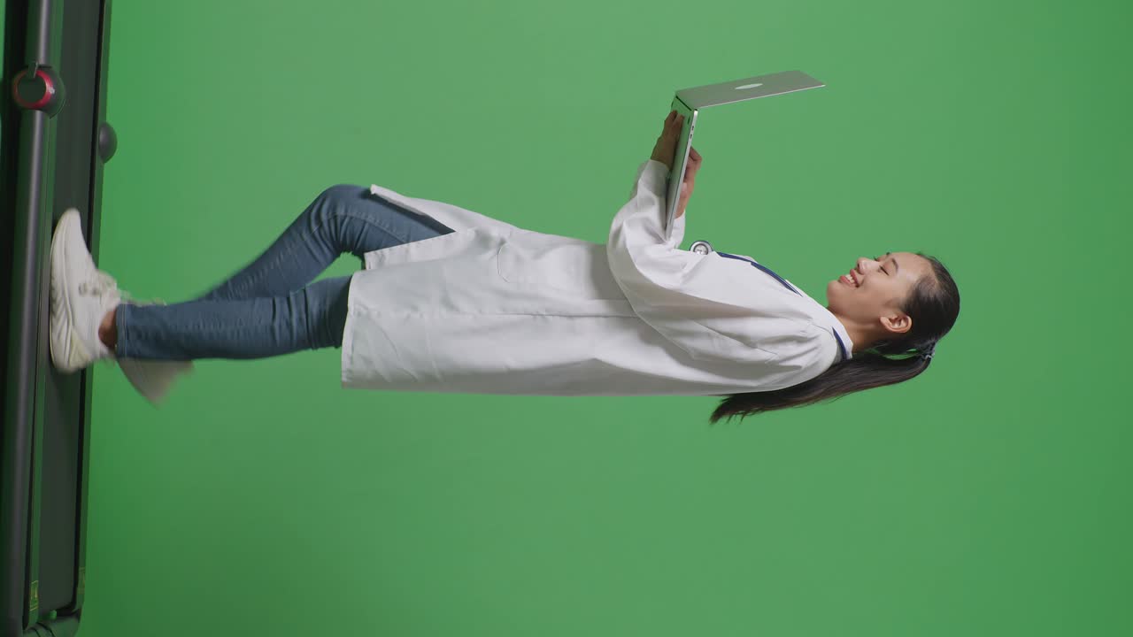 병원에서 녹색 화면 배경에서 는 동안 노트북을 사용하여 스테토스코프를 가진 아시아 여성 의사