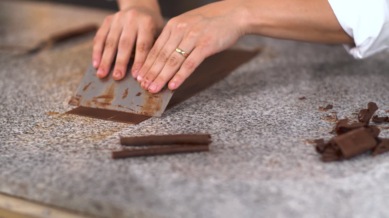 mujer panadera cortando pequeños rollos de chocolate