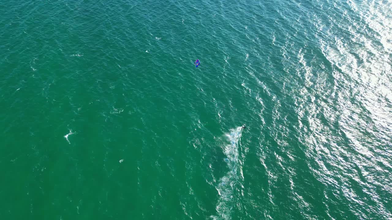 Seen from above a kitsurfer sailing in the waters of Cascais with the sun reflecting on the sea,Portugal