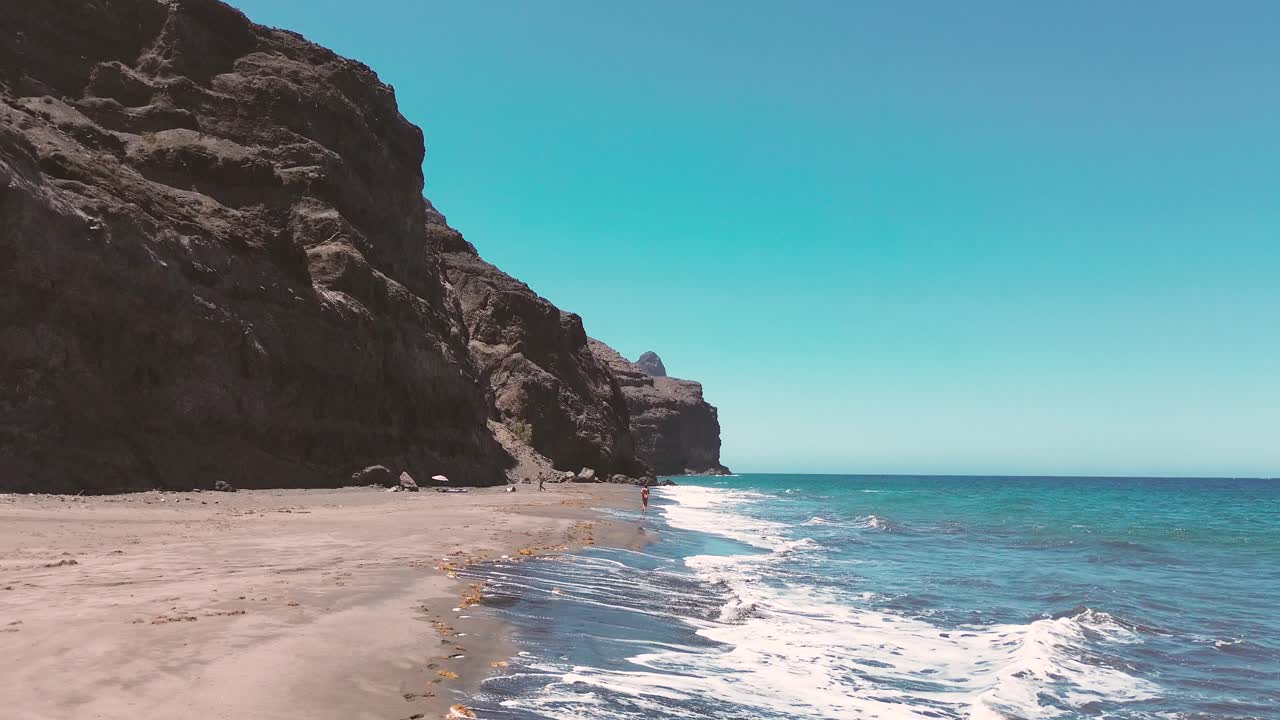 mujer corriendo en cámara lenta en la playa de gran canaria, españa durante el verano en vacaciones