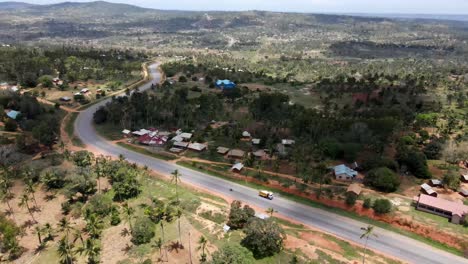 Alta-Vista-Aérea-Sobre-Un-Pequeño-Pueblo-Y-Palmeras-Al-Lado-De-La-Carretera-De-Mombasa