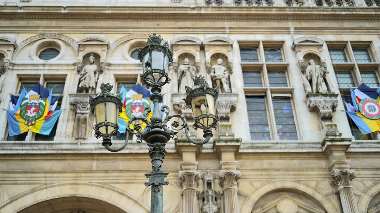 Vista dell'esterno di un vecchio edificio classico con emblemi e lampione antico a Parigi, Francia