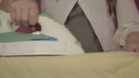 mujer planchando sábanas de la lavandería