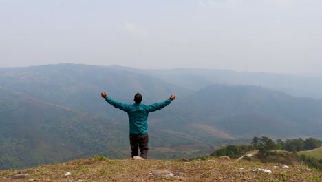 hombre disfrutando de la naturaleza en la cima de la colina con el fondo de la furia de la montaña brumosa desde un video de ángulo plano tomado en nongjrong meghalaya india