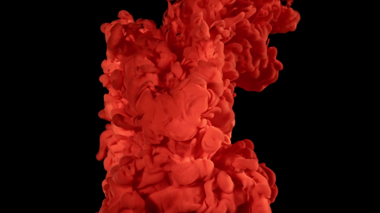 Vibrant Red Ink Cloud Expanding in Water on Black Background