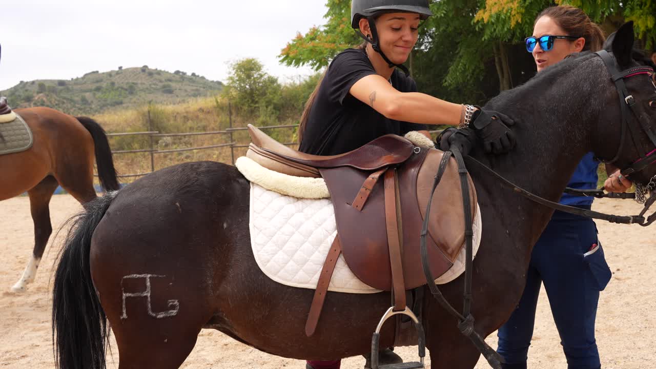 Equestrian rider caressing her pony before getting on. Day time