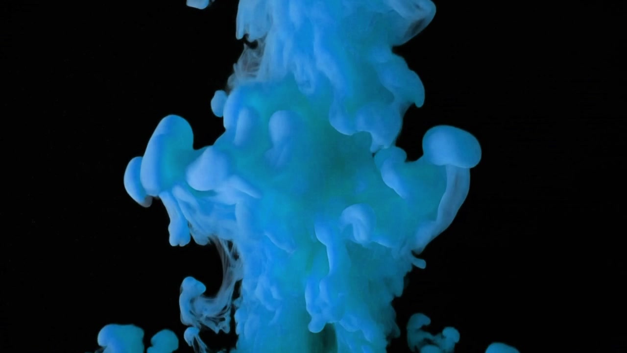 Blue Ink Dropping and Swirling in Water on Black Background