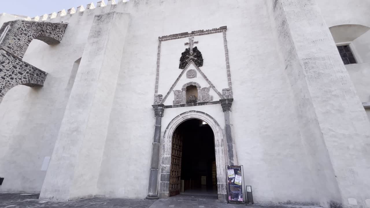 Imposing white facade of Cuernavaca cathedral, Mexico, with its historic arched door entrance
