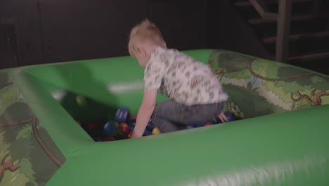 young happy boy playing in a ball pit - ungraded