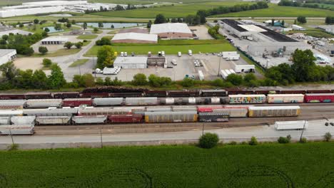 4k aerial view panning left to right of multiple trains and one starting to leave the train station