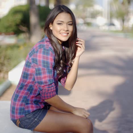 Mujer-Joven-Sentada-En-Un-Parque-De-Verano