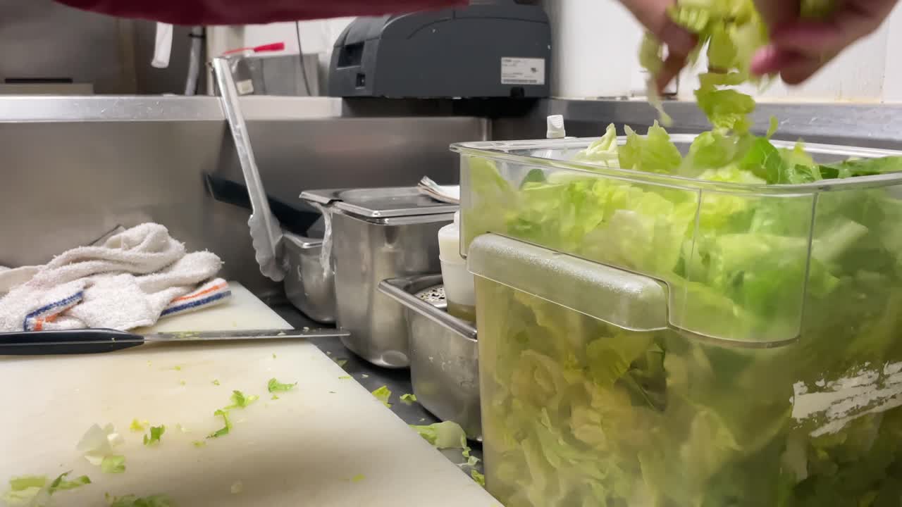 chef cutting lettuce in kitchen