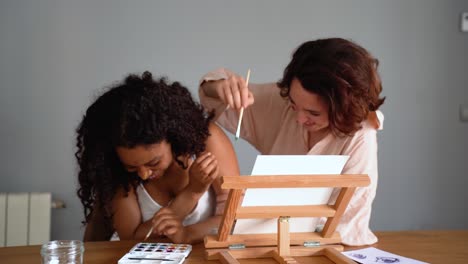 Cheerful-multiethnic-girlfriends-painting-faces-at-home