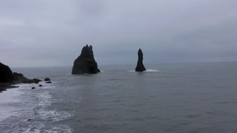 aerial: flying towards reynisdrangar sea stacks during harsh weather