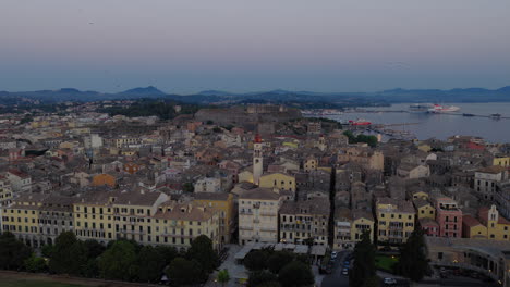 saint spyridon church and rooftops of old town corfu at sunrise, greece with swallows adding stunning presence, aerial pullback