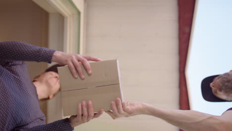 female customer takes online shopping package from courier guy, upward view