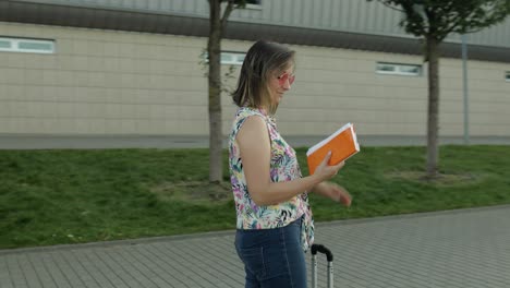 mujer de negocios turista caminando con equipaje al aeropuerto. niña se detiene y comienza a bailar, celebrar, regocijarse