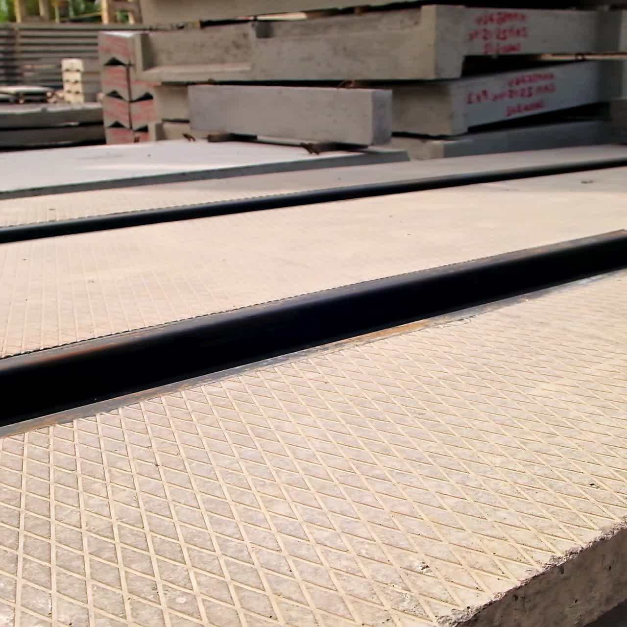 Large reinforced concrete plate with metal rails. Different ferroconcrete materials stored outside at construction site