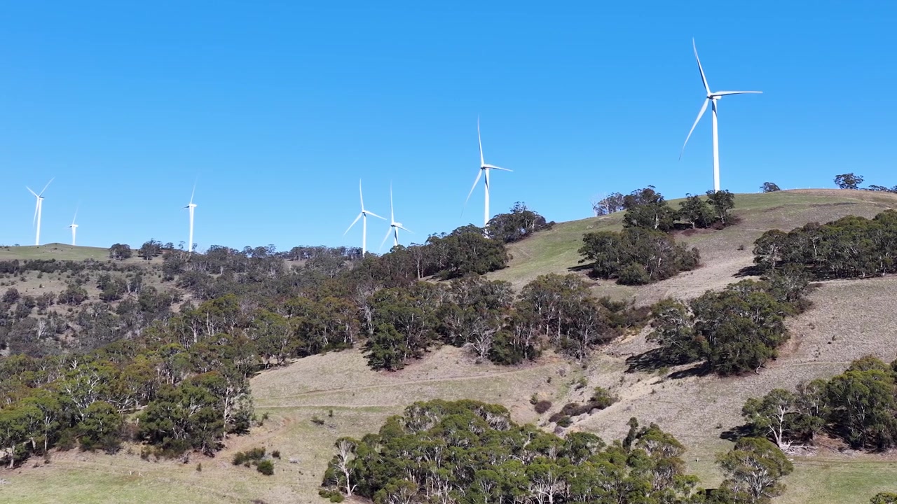 Ampia inquadratura di turbine eoliche che generano energia rinnovabile su colline erbose nel Nuovo Galles del Sud