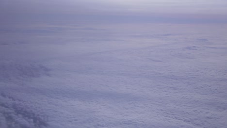 shot from plane window with lot of blue sky and some clouds