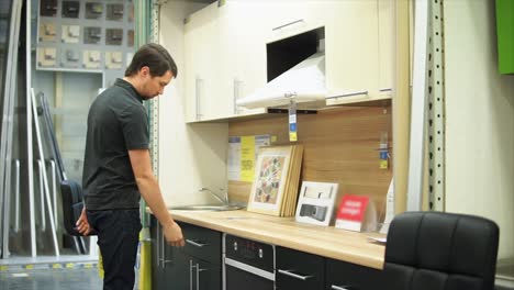 man examining kitchen cabinets in a store