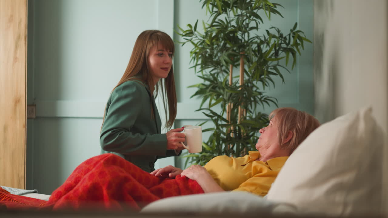 돌보는 딸은 거짓말하는  ⁇ 은 어머니에게 약과 물을 가져옵니다.