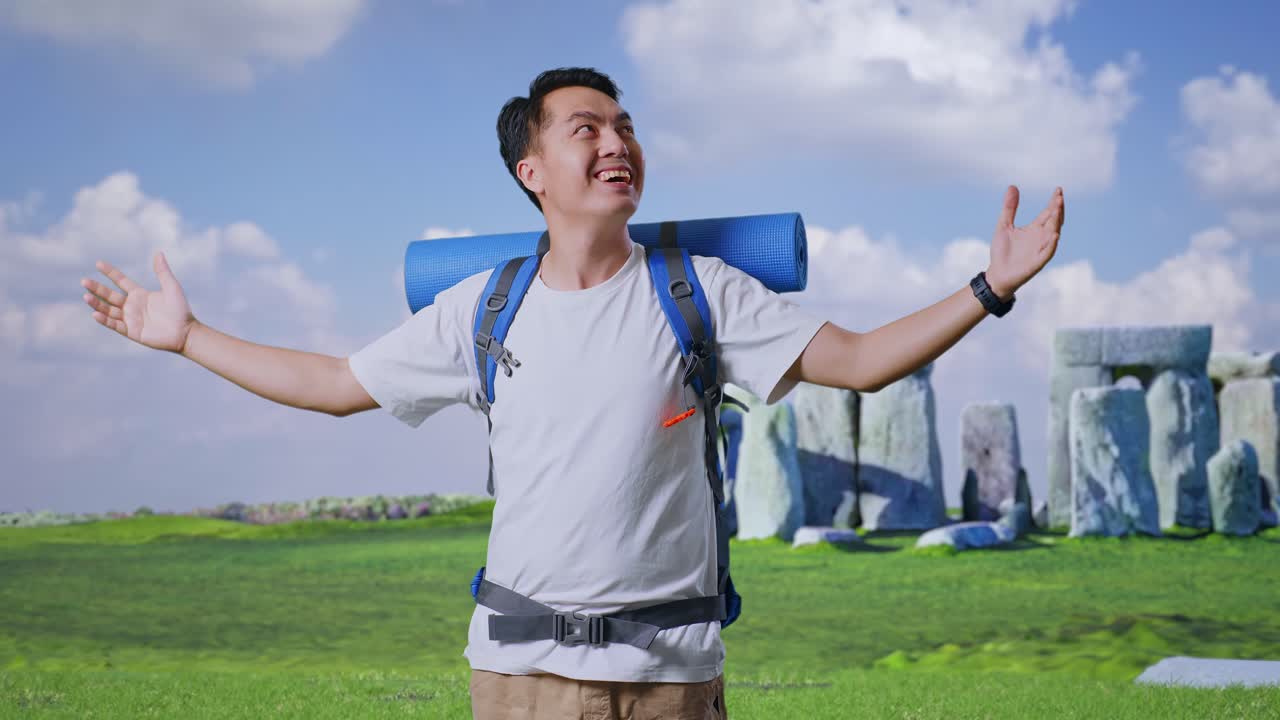 Asian Male Hiker With Mountaineering Backpack Smiling And Spreading Arms Enjoy Looking The View Around While Traveling In Stonehenge