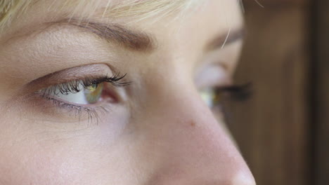 close up of young woman eyes looking pensive contemplative out window