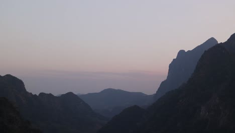 silhouette-of-mountain-peaks-at-dusk-in-the-mountain-town-of-Nong-Khiaw-in-Laos,-Southeast-Asia