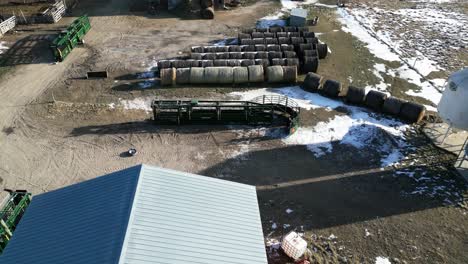 Aerial-Drone-Shot-of-Two-Women-Setting-up-a-Large-Green-Cattle-Bovine-Livestock-Squeeze-Chute-on-a-Farm