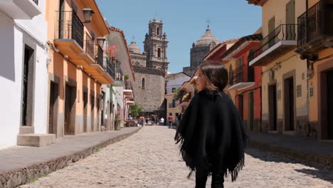 girl walking through a historic cobblestone street in an old town