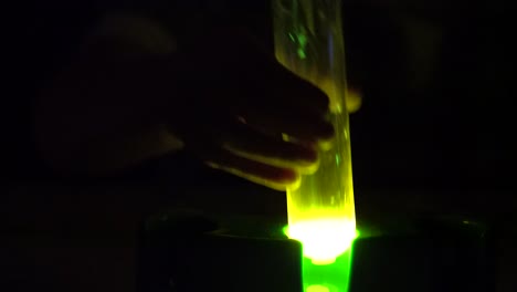 un tubo de laboratorio que brilla en la oscuridad