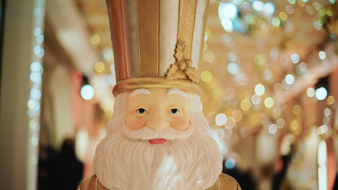 Close up of a Santa Claus figure inside a festive Christmas installation with warm lights and ornaments