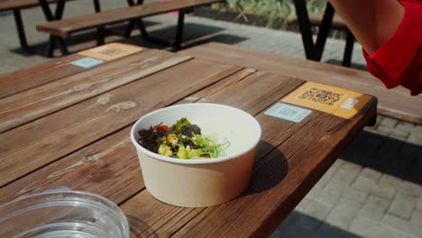 person eating korean rice bowl outdoors