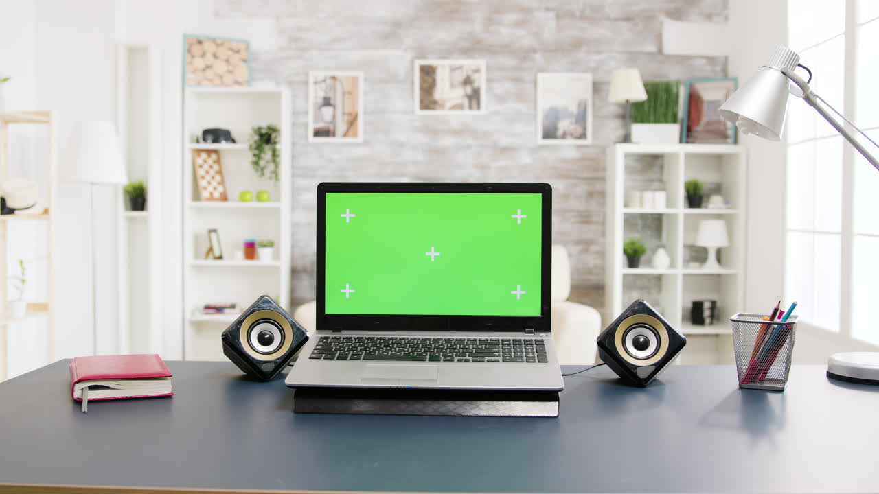 Laptop with Green Screen on Desk in Home Office