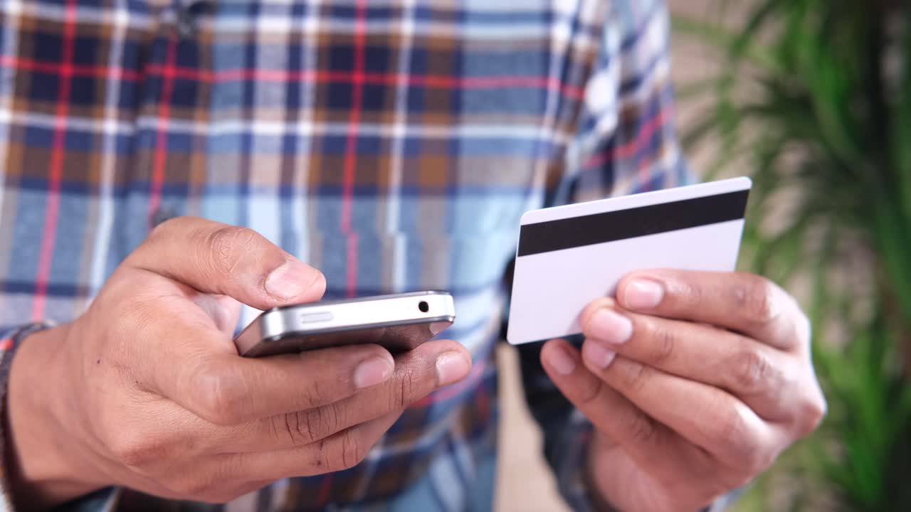 persona que utiliza un teléfono inteligente y una tarjeta de crédito para el pago en línea